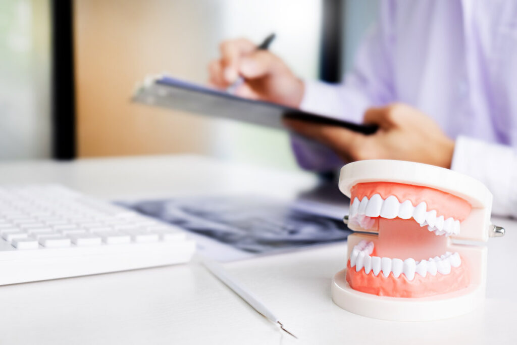 dentist with tooth model in dental office or clinic.