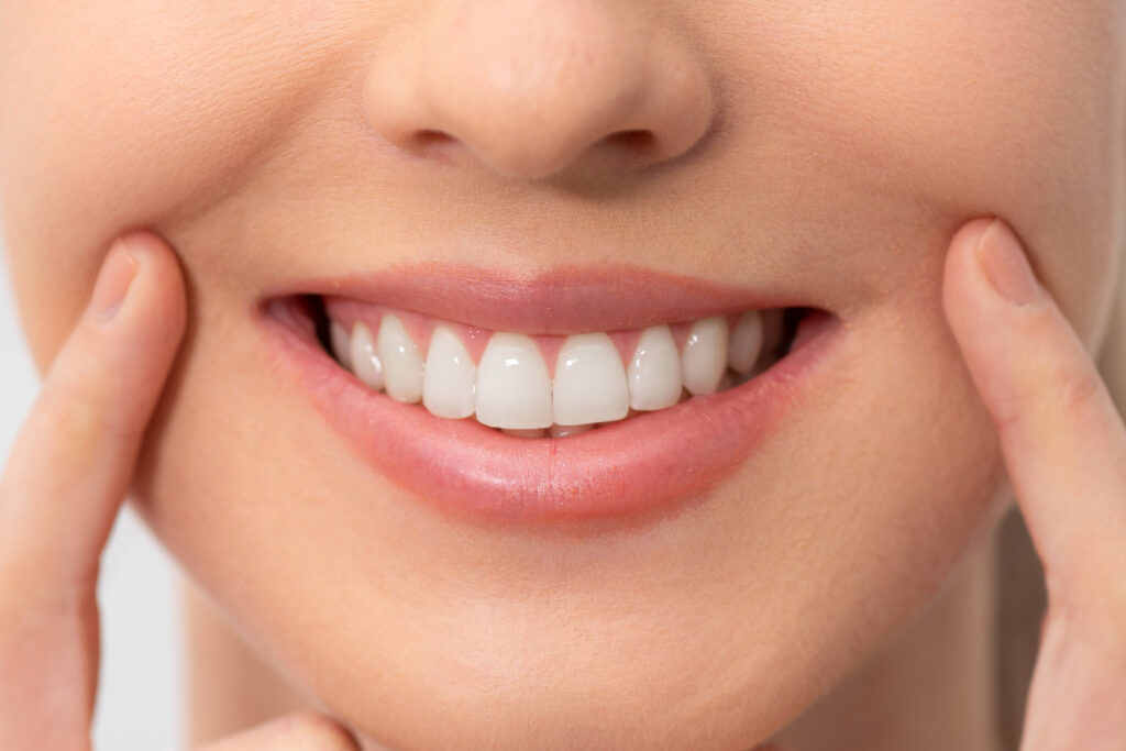 Woman showing perfect smile. Teeth whitening, dental care concept