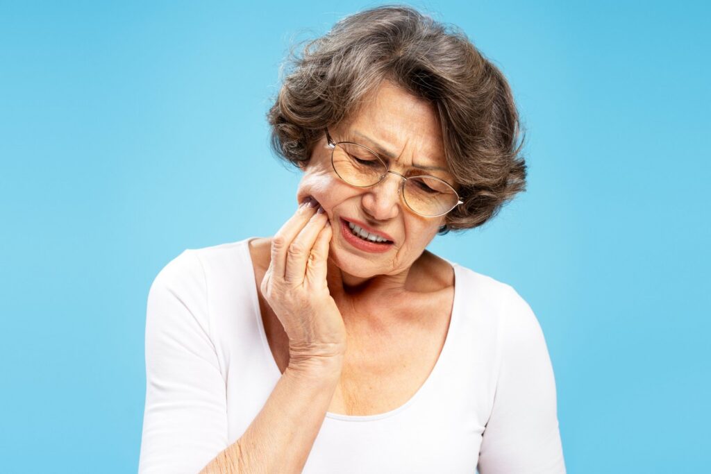 Woman holding her cheek from cracked tooth pain